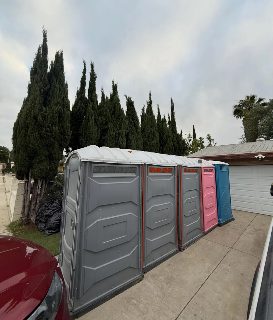 A wide portable restroom alongside other portable units