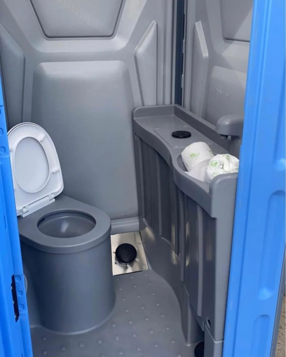 Portable restroom interior with a toilet and small sink