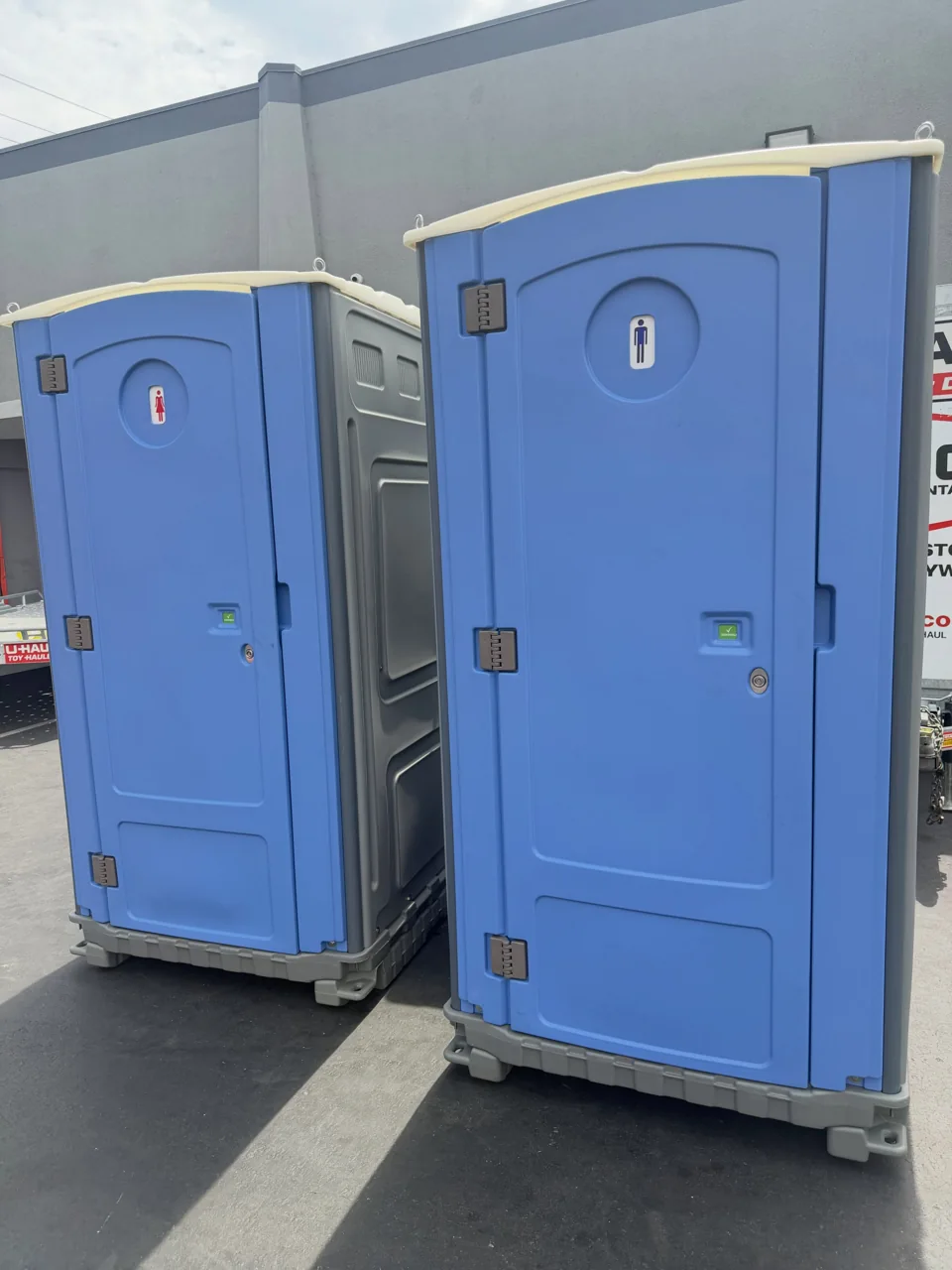 Two standard blue portable toilet exteriors